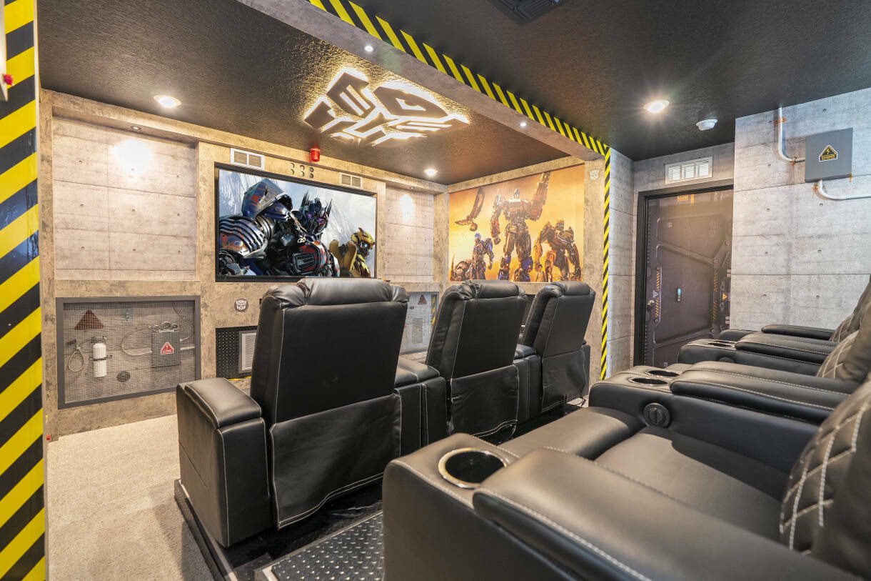Home theater com poltronas reclináveis e decoração temática, em casa de temporada em Davenport